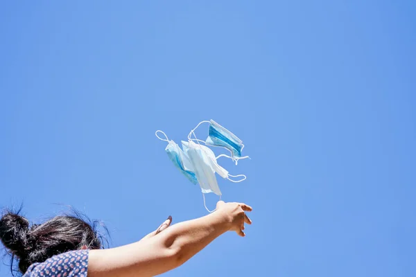 a woman flying a kite in the air with a blue sky behind her she is looking up at the sky