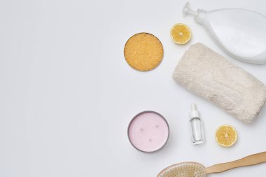 some things that are on a white surface, including soap, toothbrushs, lemon slices and other items