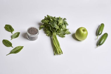 some fruits and vegetables on a white surface with an apple, avocal, celeron, cus, spinle