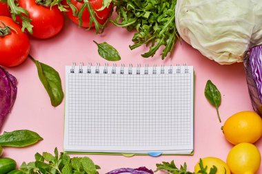 vegetables and a notepad on a pink background with space for your text or image to be written in the notes
