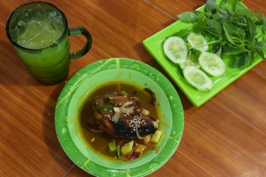 Taze sebze, tatlı ve ekşi tavuk ve portakallı buz bir masada servis edilir.