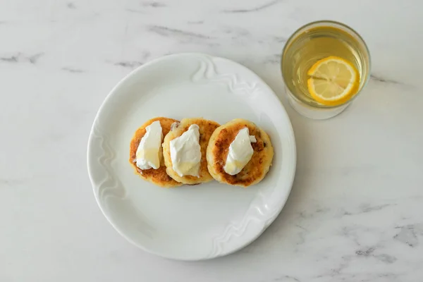 Peynirli limonlu tart ve beyaz tabakta bal.