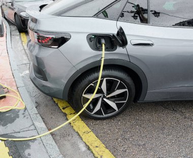 Halka açık bir otoparkta elektrikli araçlar için şarj istasyonu. Sürdürülebilir bir kaynak olarak alternatif enerji yoluyla CO2 emisyonlarını azaltarak doğa koruma kavramı.