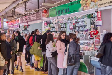 Tenerife, İspanya - 06 Ocak 2023: İnsanlar yerel ürünlerle sağlıklı ve sağlıklı gıda kavramına dayalı mağazalarla dolu bir belediye pazarında günlük alışverişlerini yapıyorlar.