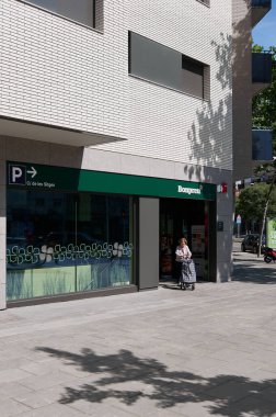 Viladecanlar - 13 Mayıs 2023: Güneşli bir günde Bonpreu alışveriş arabasıyla süpermarketten ayrılan yaşlı bayan.
