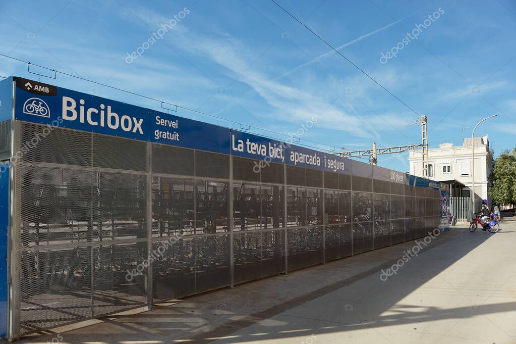 Gava - 27 de mayo de 2023: Bicibox, solución de estacionamiento masivo de  bicicletas para la estación de tren de Gava con algunos jóvenes en el fondo  en bicicletas eléctricas. 2023