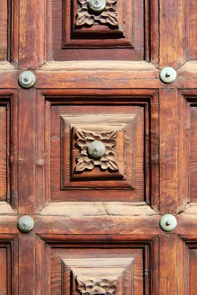 stock image CarvinCarving of a flower design in the wood of an old door with details in the center with round metal pieces.g of a flower design in the wood of an old door with details in the center with round