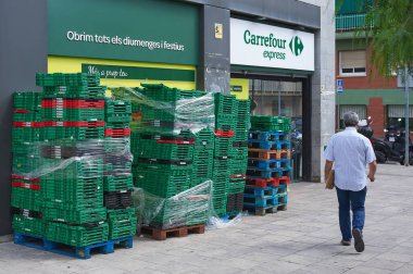 Viladecanlar, İspanya - 13 Eylül 2023: Carrefour Ekspresi 'ne bazı boş kutular ve bir kişi giriş yapıyor.