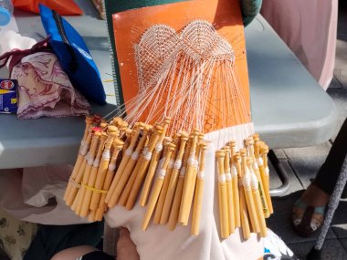 Renkli ipliklerle gerilmiş bir el dokuma resmi. El işçiliğinin ve tekstil geleneğinin güzelliğini gösteren sanatsal bir dokuma aracı..