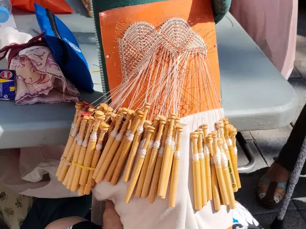 Renkli ipliklerle gerilmiş bir el dokuma resmi. El işçiliğinin ve tekstil geleneğinin güzelliğini gösteren sanatsal bir dokuma aracı..