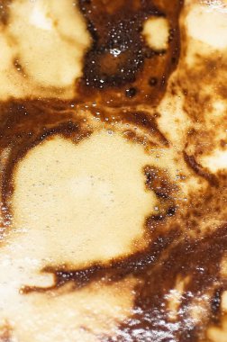 Bir sanat eserine dönüşen bir kahve köpüğünde soyut desenler olan renk ve dokuların zıtlıklarıyla oynayan bir kahve..