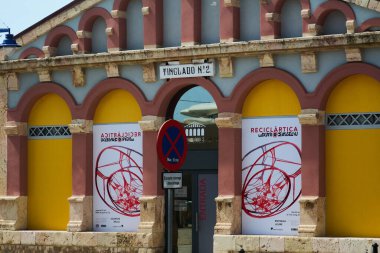 Tarragona, İspanya - 5 Nisan 2024: Tarragona 'daki Tinglado no 2' nin girişine bakın, dağınık bulutlu açık bir gökyüzü altında bir sanat sergisi ve trafik işaretleri gösteriliyor..