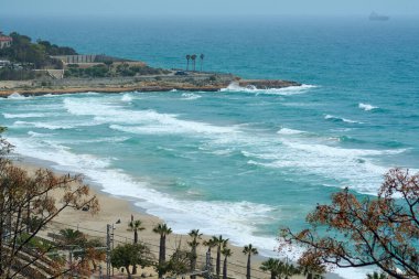 Akdeniz 'in özünü yakalayan bu görüntü, altın kumu, turkuaz suları ve sakin deniz ufkuyla Tarragona Sahili' ni vurguluyor..
