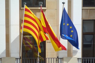 Vibrant Spanish, Catalan, and European flags flutter together, their colors a testament to the rich cultural tapestry and shared history. clipart