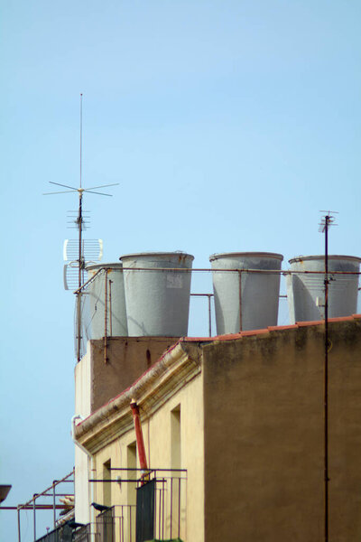 Gray reservoirs of water rise against a clear sky, capturing the essence of the urban landscape.
