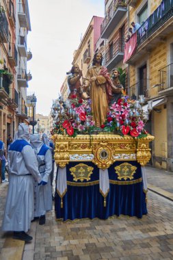 Tarragona, İspanya - 27 Nisan 2024: Saygın izleyiciler kaldırımları sıralıyor, bazıları kameralarıyla anı yakalıyor.