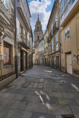Lugo, İspanya - 29 Nisan 2024: Kendi iskeleti olan binalar görkemli katedral kulesinde son bulan bir yol.