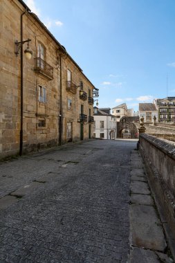 Lugo, İspanya - 08 Mayıs 2024: Lugo 'daki bir caddenin panoramik görüntüsü, açık mavi gökyüzü altında tarihi mimari ve kentsel yaşamı gösteriyor.