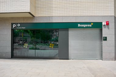 Viladecanlar, Barselona, İspanya-26 Mayıs 2024: Güneşli ve şenlikli bir günde kentsel alanda kepenkleri indirilmiş Bonpreu süpermarketi. Kapalı mağazanın kaldırımında yürüyen insanlar yok..