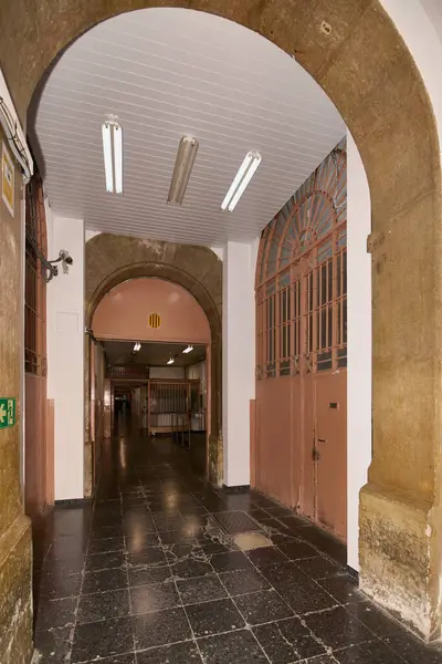 stock image Barcelona, SPAIN - JULY 6, 2024: Image of the interior hallway of Modelo Prison in Barcelona, highlighting its historic architecture with a vaulted ceiling, fluorescent lights, and shiny floors.