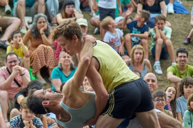 Viladecasn, İspanya - 11 Temmuz 2024: İki sporcu, spor dünyasında çok yönlülük ve sanatsal ifade sergileyerek halka açık bir etkinlikte dans ediyor.