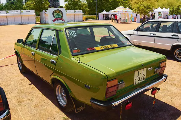 Stock image Viladecasn, SPAIN - AUGUST 12, 2024: Image of a green Seat 131 Mirafiori from 1960 parked at an outdoor event with white tents in the background. Ideal for enthusiasts of historical automobiles and