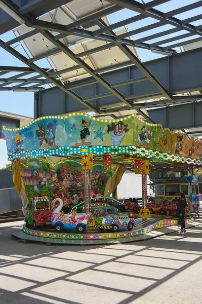 Viladecasn, SPAIN - 12 AĞUSTOS 2024: Renkli araçlar ve neşeli bir atmosfer sunan açık hava fuarında çocuk atlıkarınca gezisi.