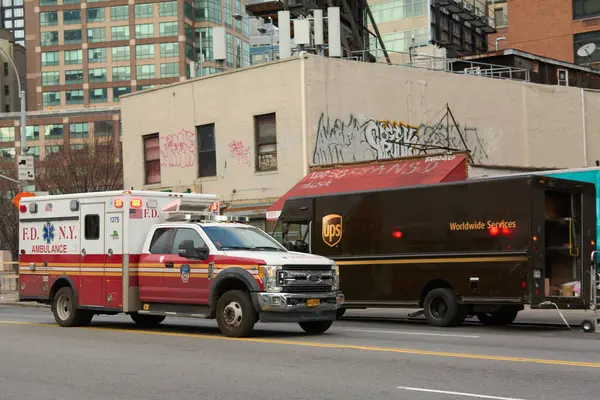 stock image New York, United States - August 27, 2024: New York fire department ambulance and UPS delivery truck on a bustling street, reflecting the city dynamism.