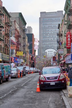 New York, ABD - 29 Ağustos 2024: Arabalar ticari tabelalar ve Çin kültürel unsurlarıyla çevrili bir animasyon caddesinde hareket ediyorlar.