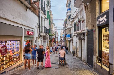 Sitges, Barcelona-Eylül 01.2024: Popüler Katalan kıyı bölgesinin ışıl ışıl güneşi altında geleneksel ve modern mimari arasında günlük hayat akıyor.