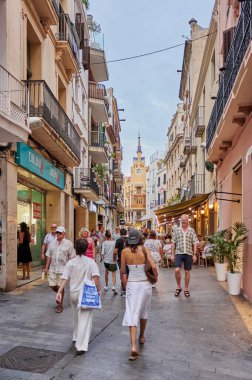 Sitges, Barcelona-Eylül 01.2024: Sitges 'deki bu sokakta turist ve yerel halkın karışımı canlı ve misafirperver bir atmosfer yaratıyor.