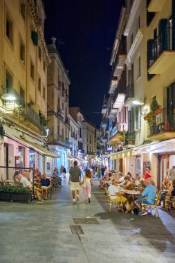 Sitges, Barcelona-Eylül 04.2024: Sitges 'de bir akşam yürüyüşü sırasında çekilen bu fotoğrafta sosyal hayat kurnazca gözler önüne seriliyor.