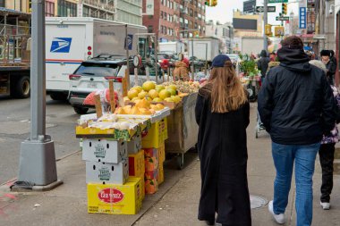 New York, ABD - Eylül 05.2024: New York 'taki Çin Mahallesi' nin bir meyve standı ve yayaların günlük yaşamlarını gösteren görüntüsü, kültürel çeşitliliği ve yerel ticareti yansıtıyor.