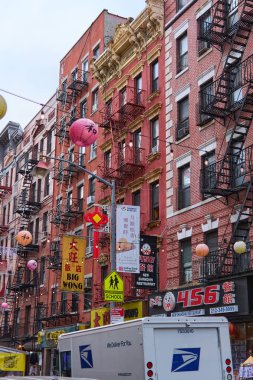 New York, Amerika Birleşik Devletleri - Eylül 05.2024: Çin Mahallesi, New York 'taki bir caddenin canlı görüntüsü, bir binanın süslemeleriyle, çoklu işlenmiş demir balkonlarıyla, ve kültürel bir dokunuş ekleyen fenerlerle.