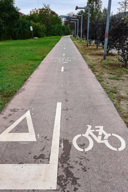 Açık tabelalı ve doğal çevresi olan bir şehir parkında bisiklet yolu, şehirde bisiklet ve sürdürülebilir hareketliliği desteklemek için mükemmel..