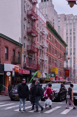 New York, United States -September 13,2024: A daily scene in Chinatown, New York, showcasing urban life with pedestrians, cars, and buildings with distinctive architectural details. clipart