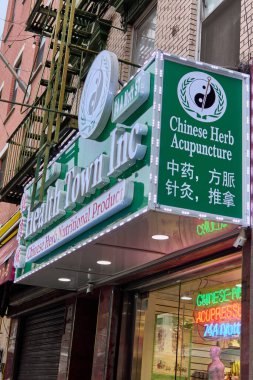 New York, ABD - 13 Eylül 2024: New York 'un Çin Mahallesi' nin göbeğinde kentsel ve kültürel temalar için mükemmel bir sağlık ve akupunktur mağazasının canlı işareti.