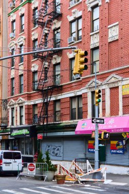 New York, ABD - 14 Eylül 2024: Tuğla binalar ve trafik işaretleri olan bir caddenin manzarası, kentsel yaşam ve yerel işletmeler için mükemmel