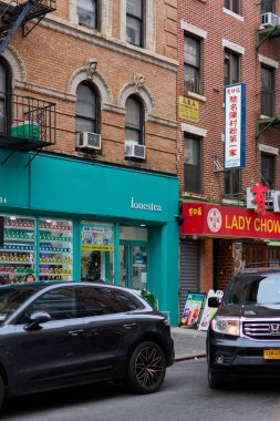 New York, ABD - 14 Eylül 2024: Çin Mahallesi, New York 'ta sokak sahnesi, harici yangın merdivenleri ve tabelalarda Çince karakterler, kültürel çeşitlilik sergileniyor.