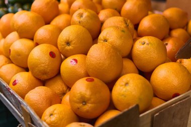 Çin Mahallesi, New York 'taki bir markette kırmızı etiketli bir kutu portakal. Görüntü portakalların dokusunu ve canlı rengini gösteriyor, taze ürünler ve sağlıklı beslenmeyle ilgili konuları göstermek için ideal..