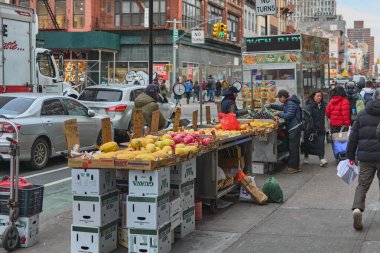 New York, ABD - 16 Eylül 2024: Çin Mahallesi, New York 'ta yayalar, bir meyve ve sebze satıcısı ve park halindeki araçlarla dolu işlek bir caddenin fotoğrafı. Kentsel yaşam ve yerel kültür temaları için ideal.