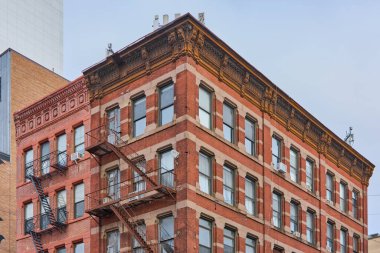 New York, ABD - 16 Eylül 2024: New York 'un ünlü Çin Mahallesi' nin tipik bir örneği olan açık bir günde süslü kornelerle süslenmiş tuğla cephesi.