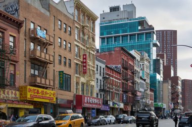 New York, ABD -16 Eylül 2024: New York 'ta sarı taksiler ve şehrin hareketlerini gösteren çeşitli dükkanlarla günlük sahne. Geleneksel ve modern mimarinin karışımı kültürel çeşitliliği vurguluyor.