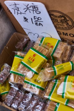 New York, Amerika Birleşik Devletleri - 19 Eylül 2024: Bir markette karton bir kutuya Çin şekerlerini tek tek sarıp Çin mutfağı kültürünün çeşitliliğini gözler önüne sermek.
