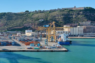 Barselona 'da. Espain - 20 Ekim 2024: Barcelona limanının kargo gemisi yanaşmış ve vinçler boşaltılıyor. Liman etkinliğini ve küreselleşmeyi temsil eder.