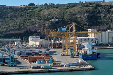 Barcelona. Espain -October 20,2024: Hapag-Lloyd cargo ship in the process of unloading at Barcelona port, captured with cranes in operation and a clear sky. Ideal for representing global transport. clipart