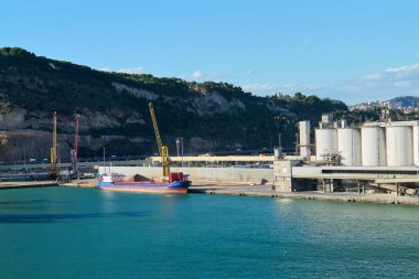 Barselona 'da. Espain - 20 Ekim 2024: Barcelona 'daki konteyner terminali, kargo gemisi ve birden fazla vinç çalışıyor. İthalat, ihracat ve deniz taşımacılığı konuları için mükemmel.
