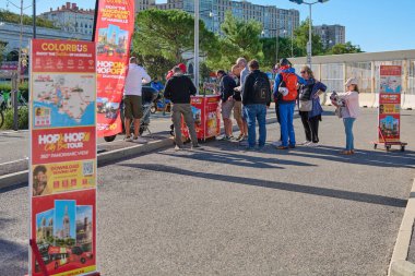 Marsilya. Fransa - 21 Ekim 2024: Turistler, Marsilya tur otobüsüne bilet almak için sokakta toplandılar. Sahne, bilet gişesinin reklamındaki çeşitli posterlerle dolu..