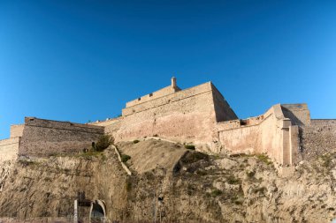Fransa 'nın Marsilya kalesindeki Saint-Nicolas Kalesi' nin genel manzarası güneşli bir günde açık gökyüzü ile kayalık üssüyle.