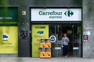Viladecanlar. İspanya - 7 Kasım 2024: Bir Carrefour Express süpermarketinin dış cephesi, mağazaların markalaşma ve tanıtım tekliflerini vurguluyor. Kentsel ortam altı çizili